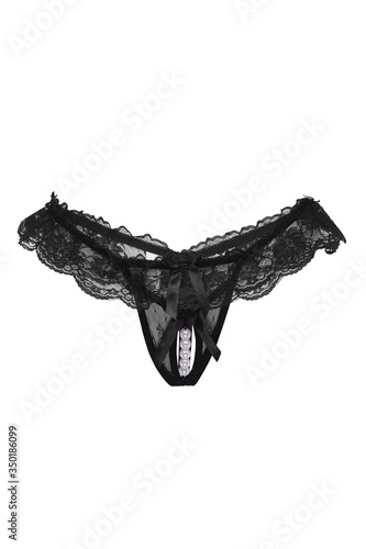 Detailed shot of a black lace G-string with a cutout in the intimate area and decorated with ruffles and a pearl string. The sexy panties are isolated on the white backdrop. 