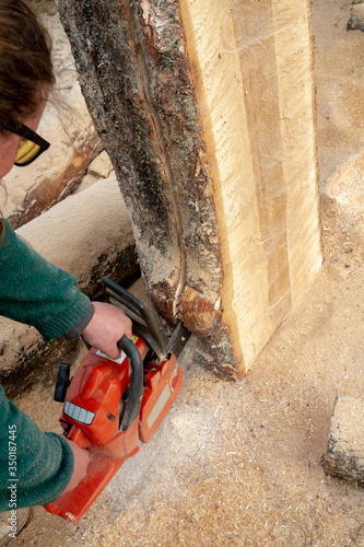 A man is sawing a log in the longitudinal direction. Manual board manufacture