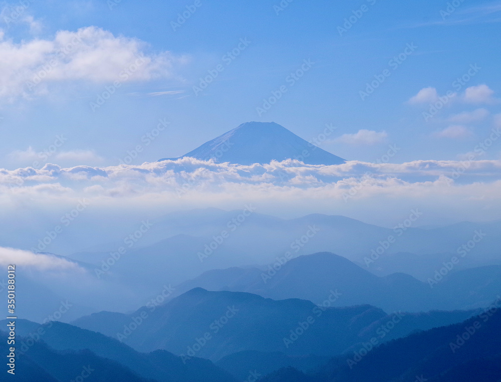 View of snow-capped Mt. Fuji as seen 40.88 km (25.40 mi) away on the peak Mt. Tonodake with sharp ridges of the Tanzawa mountain range in the foreground.