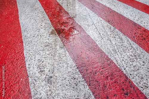 abstract background of red and white markings for fire fighting equipment on wet pavement after a rain, perspective view