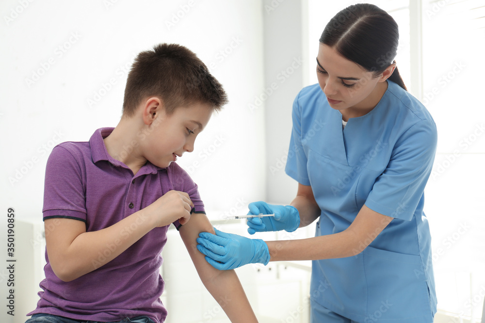 Doctor vaccinating little child in modern clinic Doctor vaccinating little child in modern clinic