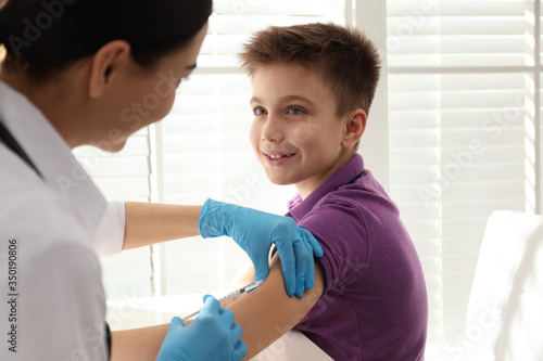 Doctor vaccinating little child in modern clinic