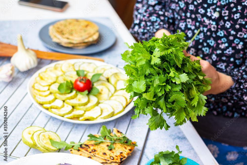 Woman hold fresh green herbs in hands. A bunch of parsley Woman hold fresh green herbs in hands. A bunch of parsley