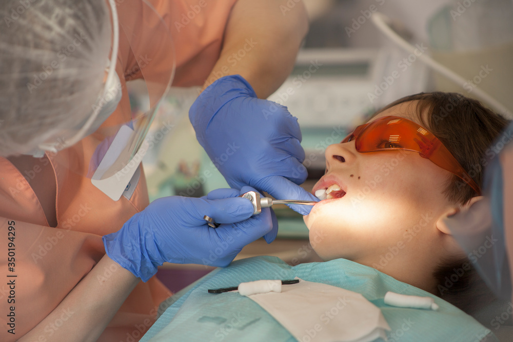 stomatology and health care concept , dental treatment of young male patient in dental clinic stomatology and health care concept , dental treatment of young male patient in dental clinic