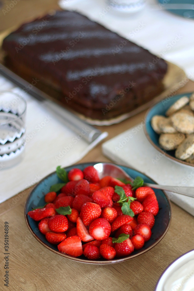 Bowl of strawberries served on set table. Selective focus. Bowl of strawberries served on set table. Selective focus.