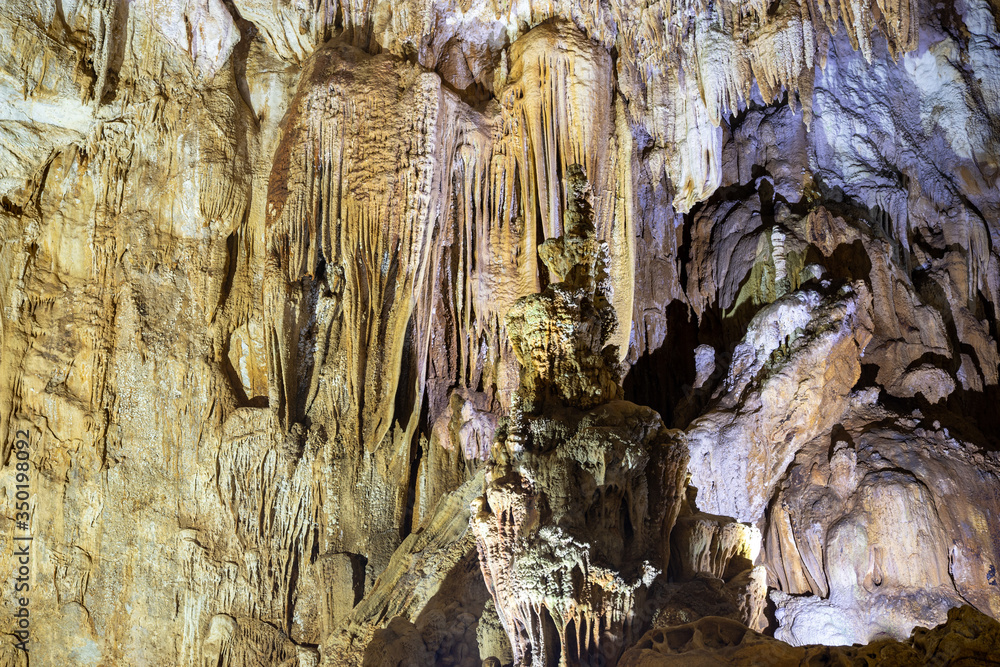 Enormous stalagmites and statuesque stalactites rising from the ground and hanging from the ceiling in a cave Enormous stalagmites and statuesque stalactites rising from the ground and hanging from the ceiling in a cave