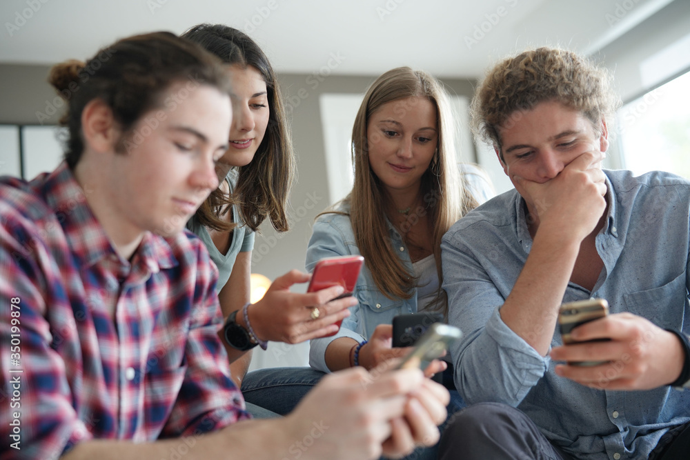 group of four young people with their phone group of four young people with their phone