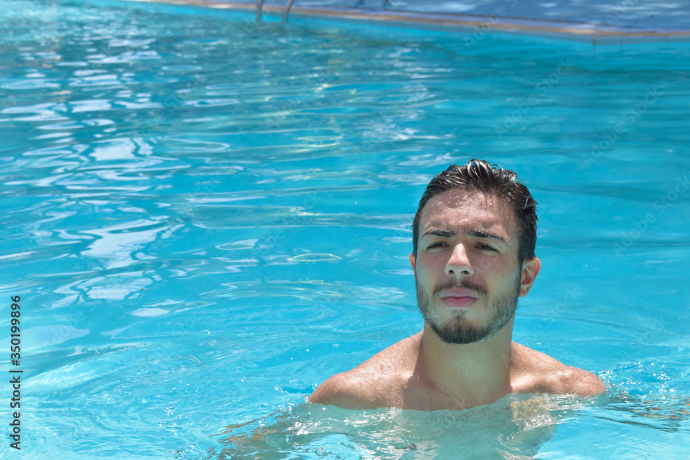 Guy with serious look white brown dipped in pool with wet hair on face and eyes
