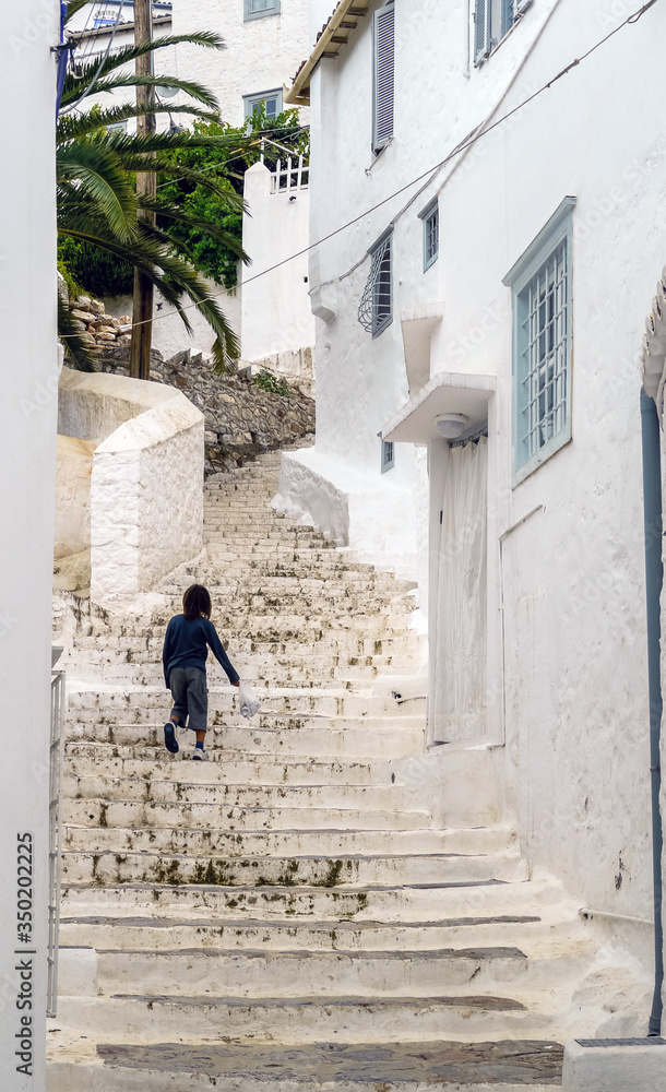 Hydra, Attica / Greece - June 6, 2010: One kid climbing the stairs in the historic village center