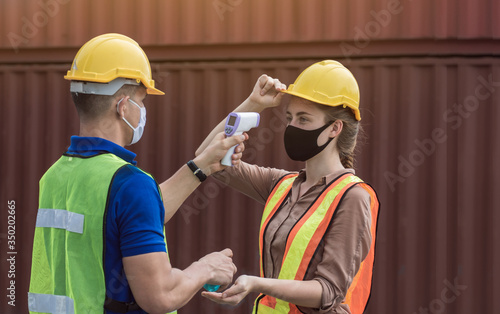 Worker is checking fever of his colleague