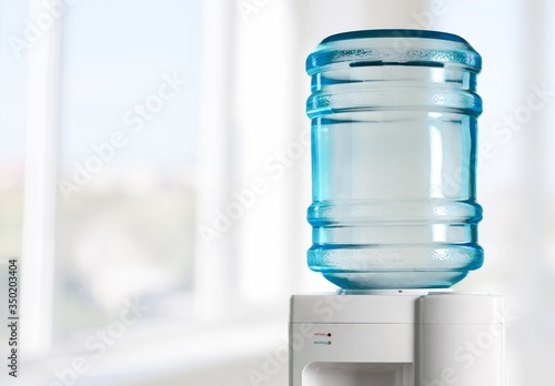 Plastic water cooler over office background