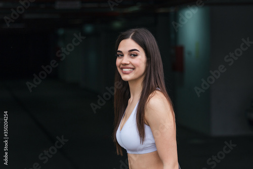 Beautiful fitness girl walking on the gym, young pretty woman in sportswear portrait