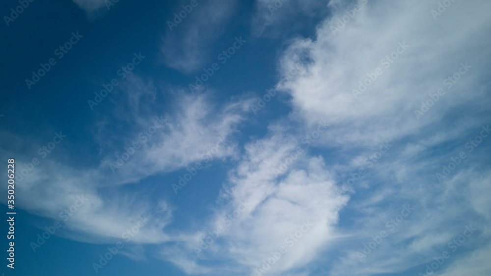 Wide,light blue sky with white air clouds stretching away into distance on beautiful bright sunny day.Horizontal banner,texture or abstract backdrop for text,blog,design,agency,website,pattern,model Wide,light blue sky with white air clouds stretching away into distance on beautiful bright sunny day.Horizontal banner,texture or abstract backdrop for text,blog,design,agency,website,pattern,model