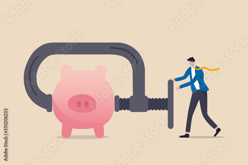 Business or company cut budget or squeeze and reduce spending due to business or economic crisis in COVID-19 Coronavirus recession concept, businessman using clamp to squeeze saving pink piggy bank