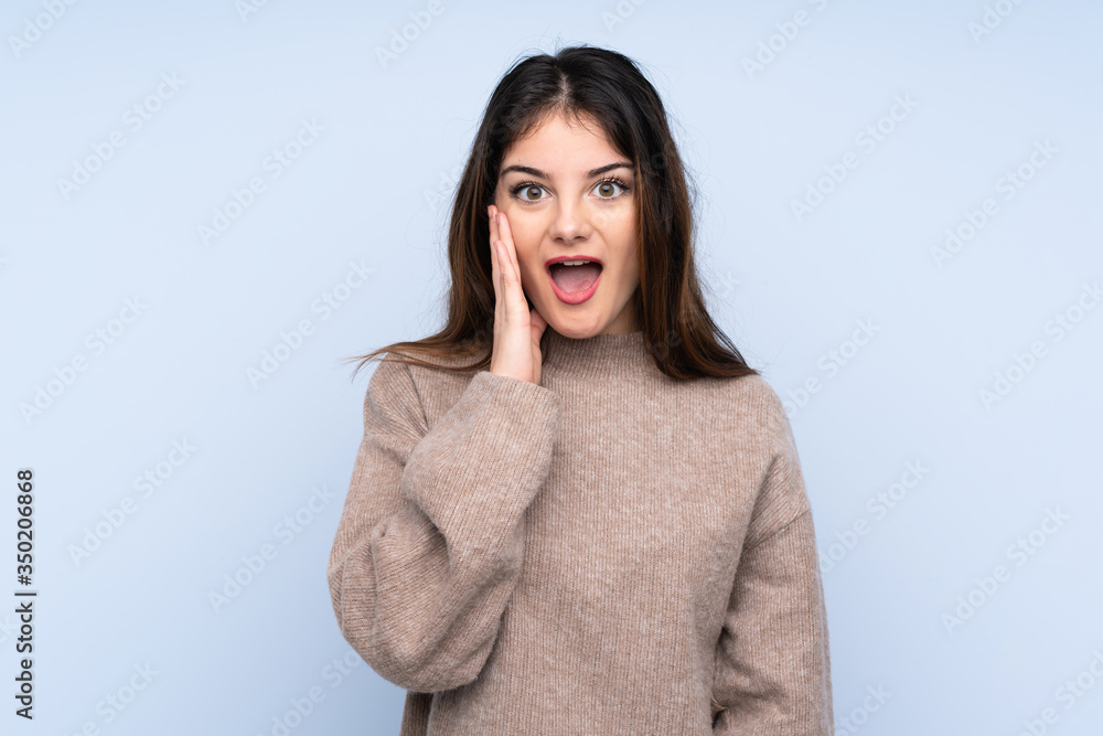 Young brunette woman wearing a sweater over isolated blue background with surprise and shocked facial expression Young brunette woman wearing a sweater over isolated blue background with surprise and shocked facial expression