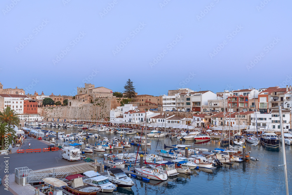 View of the old port in town Ciutadella with boats and restaurants (beautiful evening light)