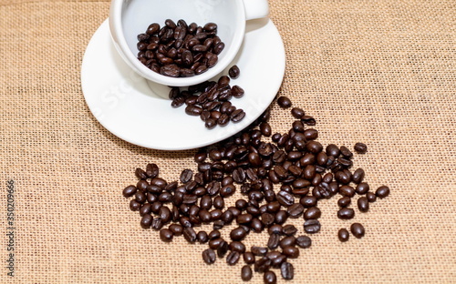 Cup of coffee with coffee beans on old background