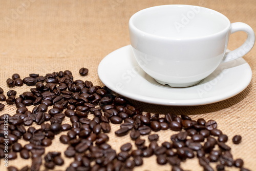 Cup of coffee with coffee beans on old background