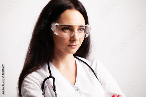 Doctor with protective goggles and stethoscope on her workspace
