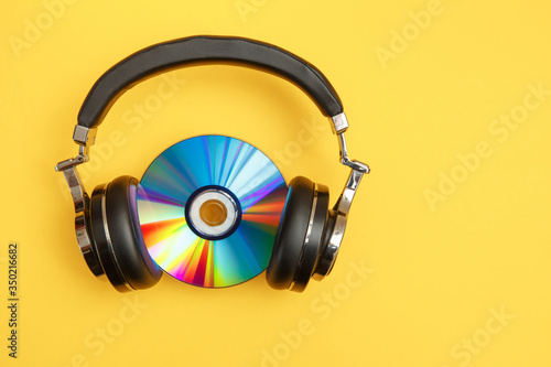 Headphones and music disc on a yellow background.
