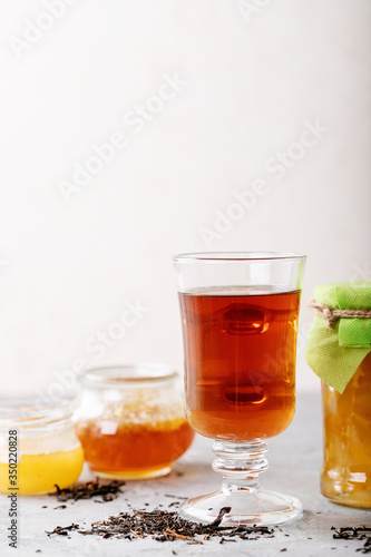 Glass cup of black tea served with honey