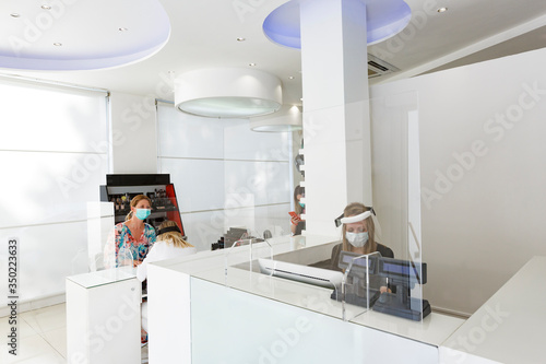 Fototapeta Naklejka Na Ścianę i Meble -  Salone di parrucchieri allestito secondo le regole per la protezione del personale e dei clienti con plexiglass separatori equipaggiamento di personale e clienti.