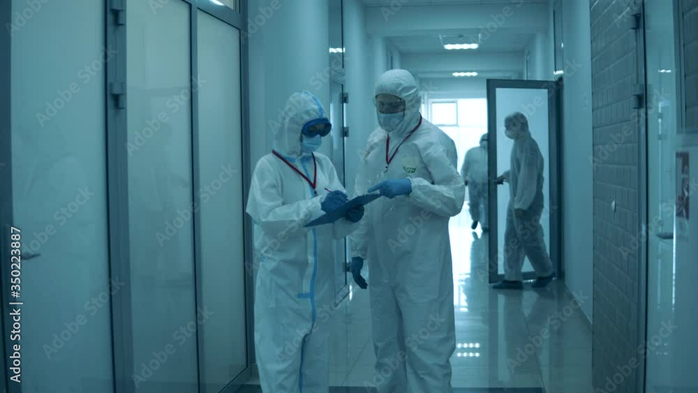 People work at clinic, wearing protective suits during pandemic. People work at clinic, wearing protective suits during pandemic.