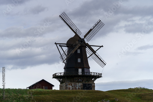 Old Windmill on a hill in south Sweden with cloudy sky in the background.