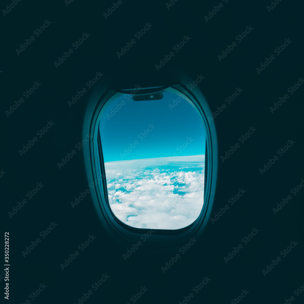 View from the plane window to the clouds and pale blue sky during the flight View from the plane window to the clouds and pale blue sky during the flight