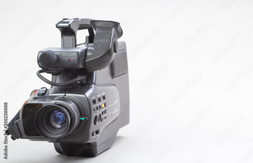 The video camera with the microphone isolated on white, in concept of technology, entertainment. Retro camcorder