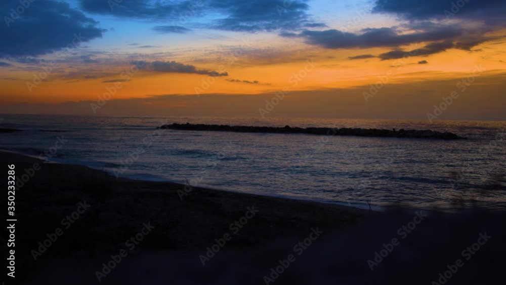 Gorgeous orange sunset on Mediterranean Sea. Dark waves of calm ocean water crashing on the beach. Evening on Cyprus. Beauty in nature, tranquility, landscape, seascape. Gorgeous orange sunset on Mediterranean Sea. Dark waves of calm ocean water crashing on the beach. Evening on Cyprus. Beauty in nature, tranquility, landscape, seascape.