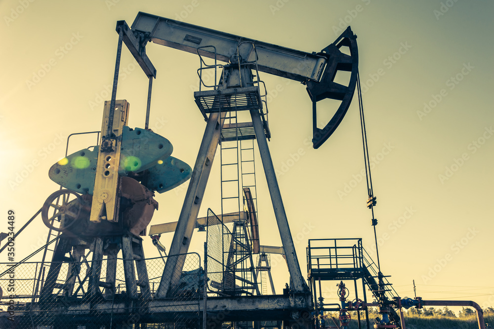 Oil pump rig. Oil and gas production. Oilfield site. Pump Jack are running. Drilling derricks for fossil fuels output and crude oil production. War on oil prices. Global coronavirus COVID 19 crisis. Oil pump rig. Oil and gas production. Oilfield site. Pump Jack are running. Drilling derricks for fossil fuels output and crude oil production. War on oil prices. Global coronavirus COVID 19 crisis.