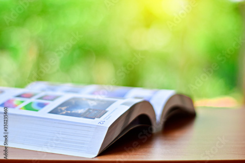 Open book on table on natural background with sunlight and copy space