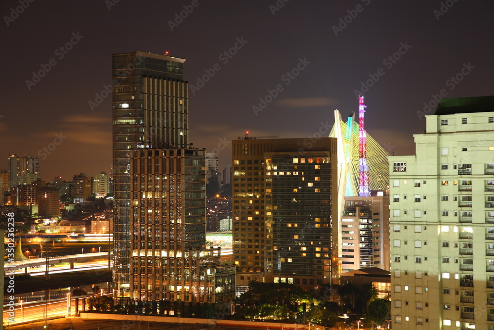 Fototapeta premium Sao Paulo city skyline with Octavio Frias de Oliveira Bridge and Morumbi district during night, Brazil