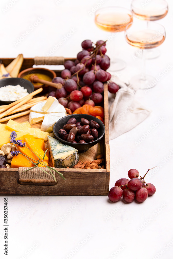 Tray with cheese assortment served with rose wine Tray with cheese assortment served with rose wine