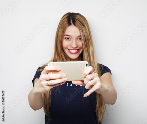 Pretty young woman taking selfie.