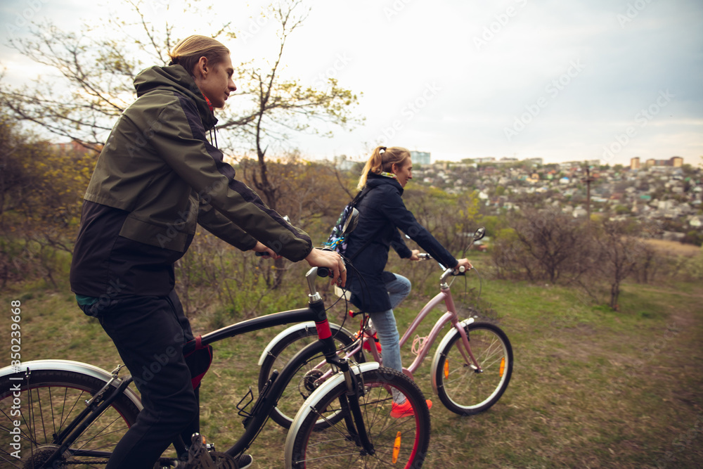 Best friends having fun near countryside park, riding bikes, spending time healthy. Calm nature, spring day, positive emotions. Sportive, active leisure activity. Traveling or walking together. Best friends having fun near countryside park, riding bikes, spending time healthy. Calm nature, spring day, positive emotions. Sportive, active leisure activity. Traveling or walking together.
