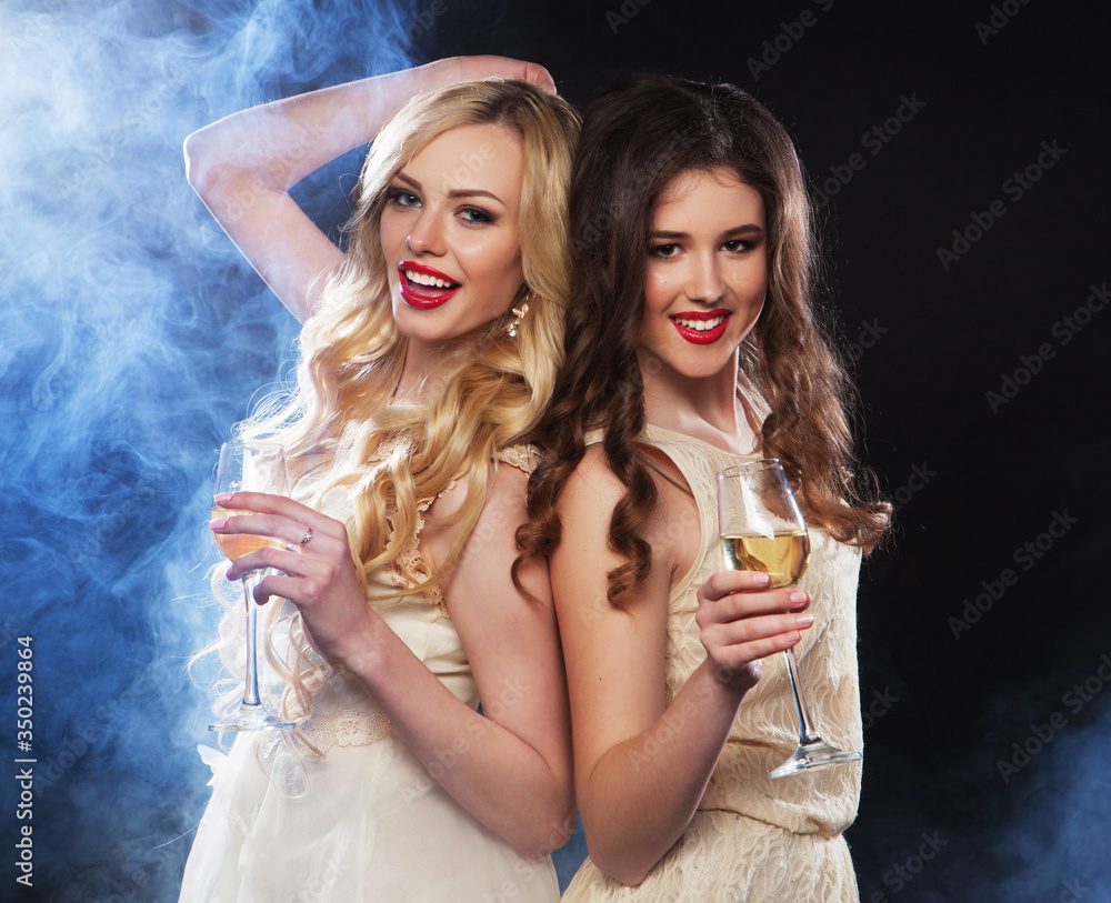 Group of partying girls clinking flutes with sparkling wine