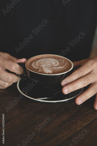Closeup of hands with coffee cups in a cafe