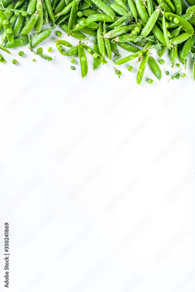Fresh green pea pods and green peas on the white background, top view 