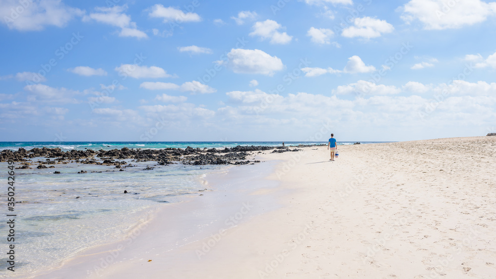 freedom concept, a man walks along the beach on the island of Fuerteventura Spain, Corralejo beach freedom concept, a man walks along the beach on the island of Fuerteventura Spain, Corralejo beach