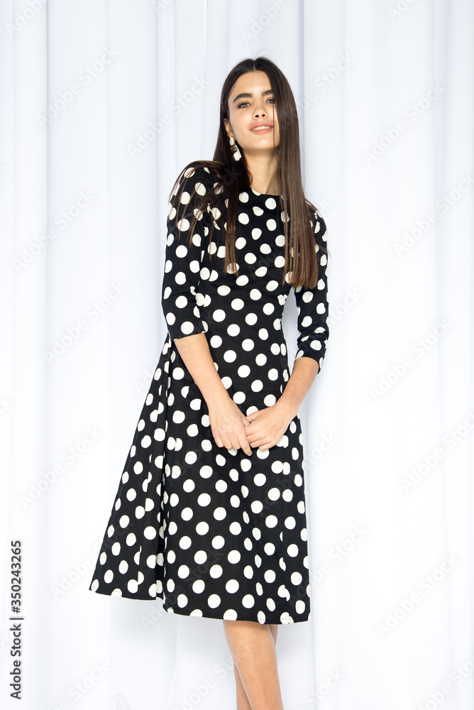 Fashion catalog dynamic photography of a young brunette girl, on a background of white texture. Beautiful holiday dresses, dress. Black and white style. Fashion catalog dynamic photography of a young brunette girl, on a background of white texture. Beautiful holiday dresses, dress. Black and white style.