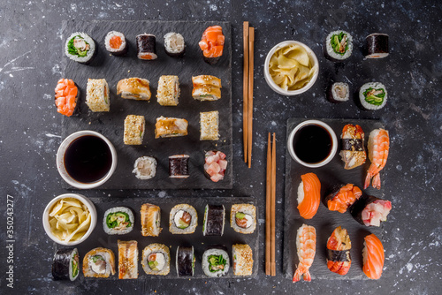Japanese food. Big sushi set. Assorted set of various sashimi, maki and sushi rolls with different fillings - tuna, sea bass, salmon, shrimp, vegetables. Flatlay copy space