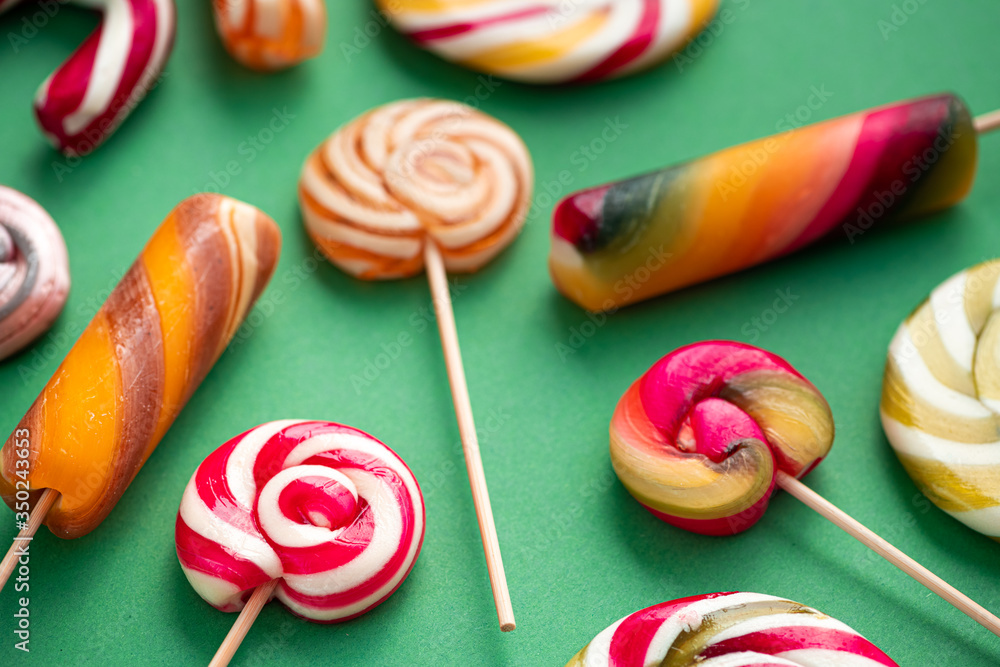 Tasty candy lollypops different colors on a green Tasty candy lollypops different colors on a green