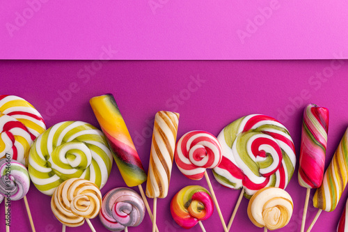 Lollypops kids food on a trend violet color background.