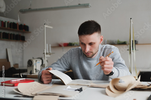 Man doing engineering or managing work at a generic workshop. Local small business, clothing designer portrait photo