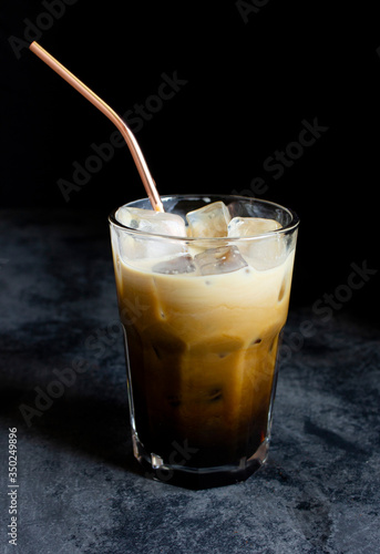 Wallpaper Mural Iced coffee with milk in a tumbler glass cup with a metal straw on a dark background Torontodigital.ca