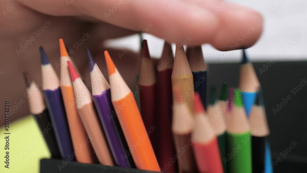 Female hand straightens pencils in box Female hand straightens pencils in box
