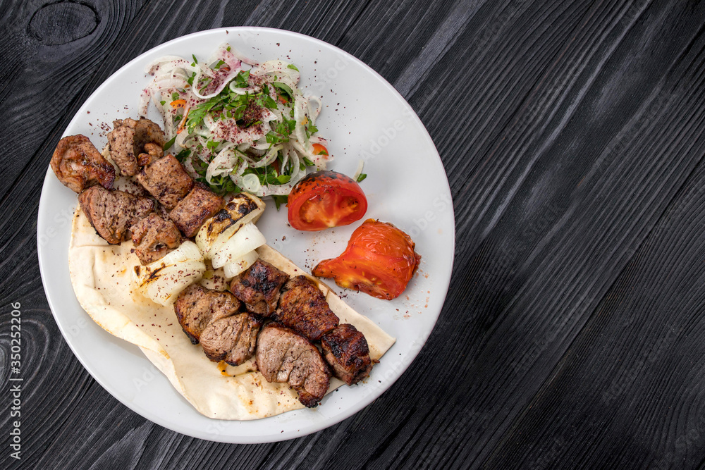 grilled meat on pita bread with salad on a black wooden background grilled meat on pita bread with salad on a black wooden background