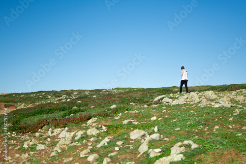 Homem andando sozinho na paisagem.